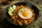 Nasi goreng s kuřecím masem, sázeným vejcem, okurkou a limetou